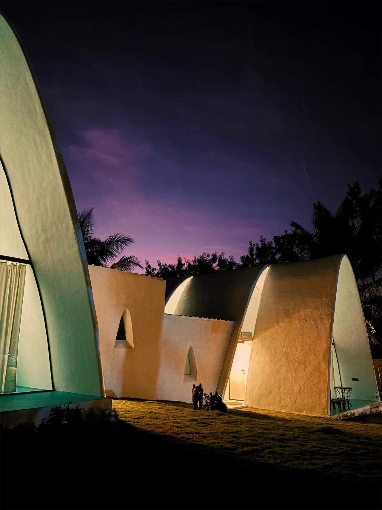 The concrete shells glowing at dusk under a violet sky