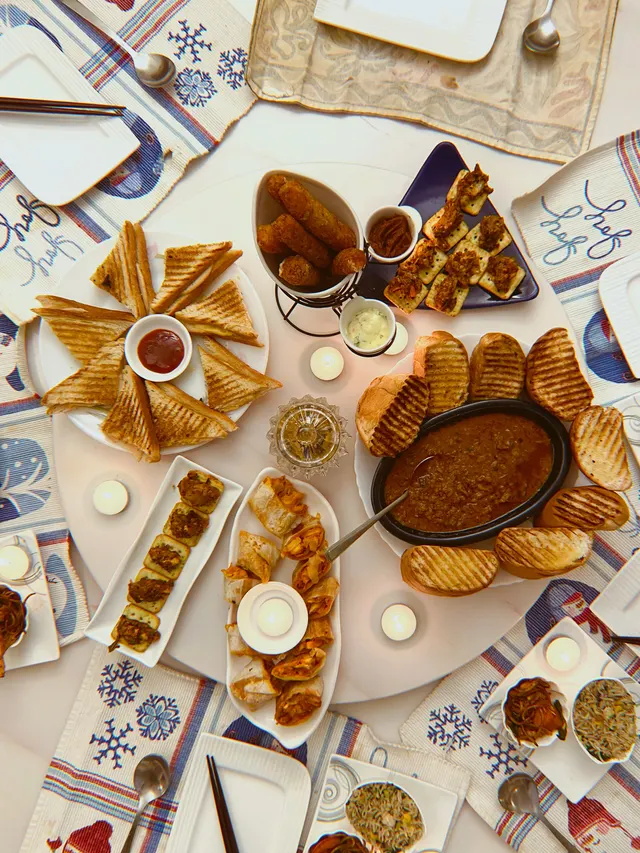 Tea-time sandwiches, fritters and chutneys laid out on the table